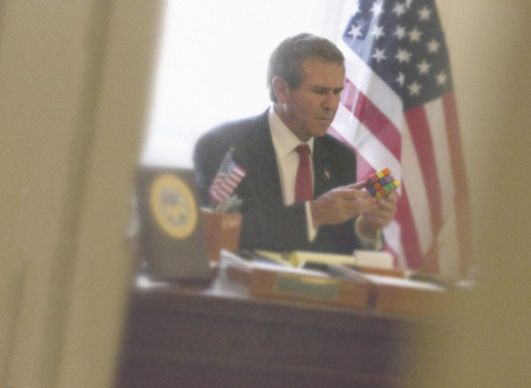 O então presidente dos EUA, George Bush, diverte-se com um cubo de Rubik, 2005 - ALISON JACKSON